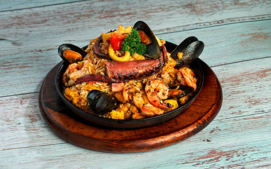 Paella valenciana com camarão, mexilhão, polvo e lula, servida na frigideira de ferro